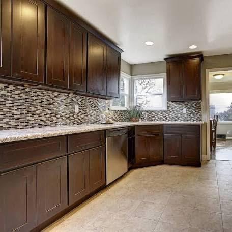 Renovated kitchen with wood cabinets and mosaic backsplash
